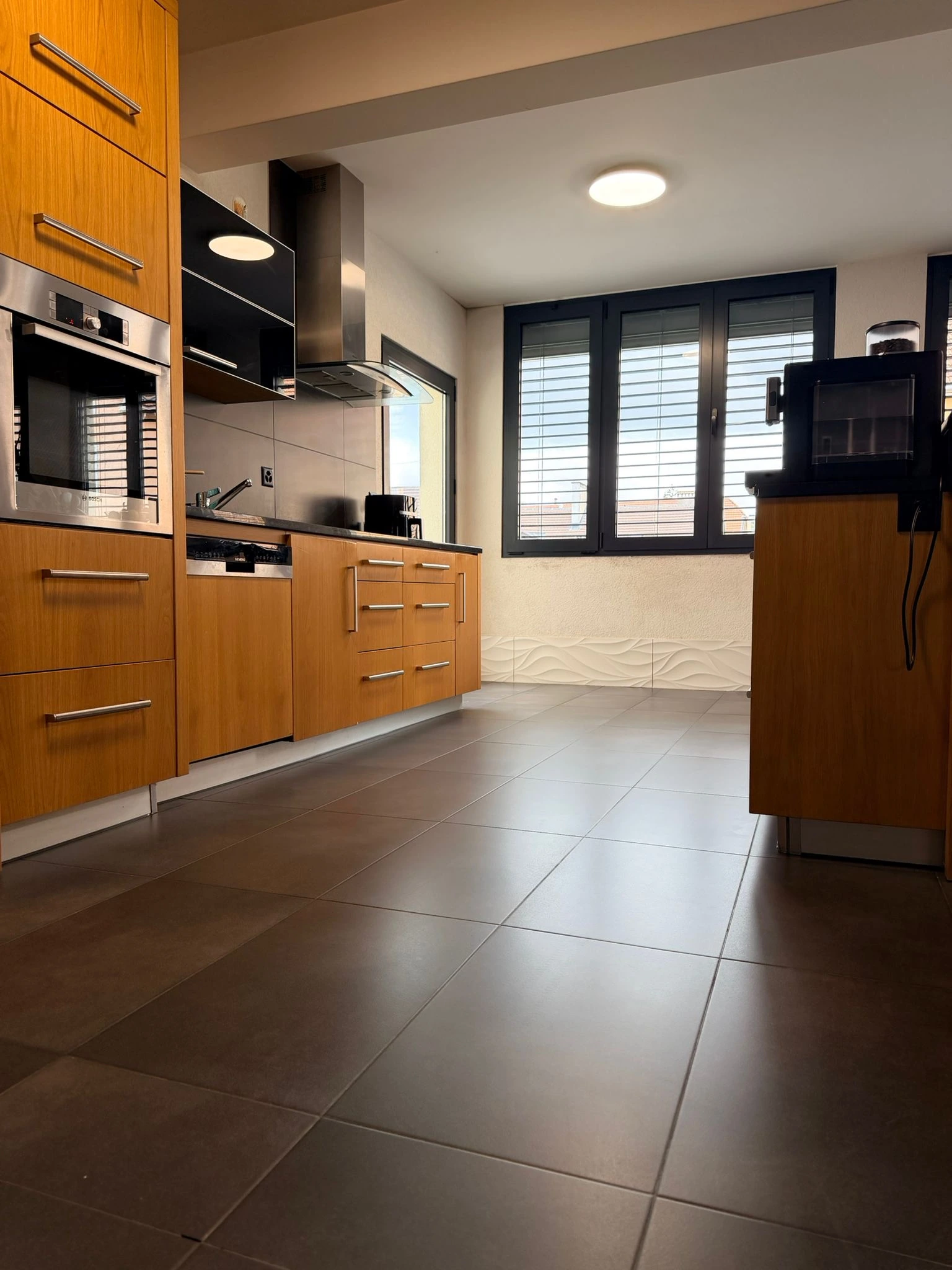 Cuisine avec carrelage de sol gris anthracite et faïence murale décorative