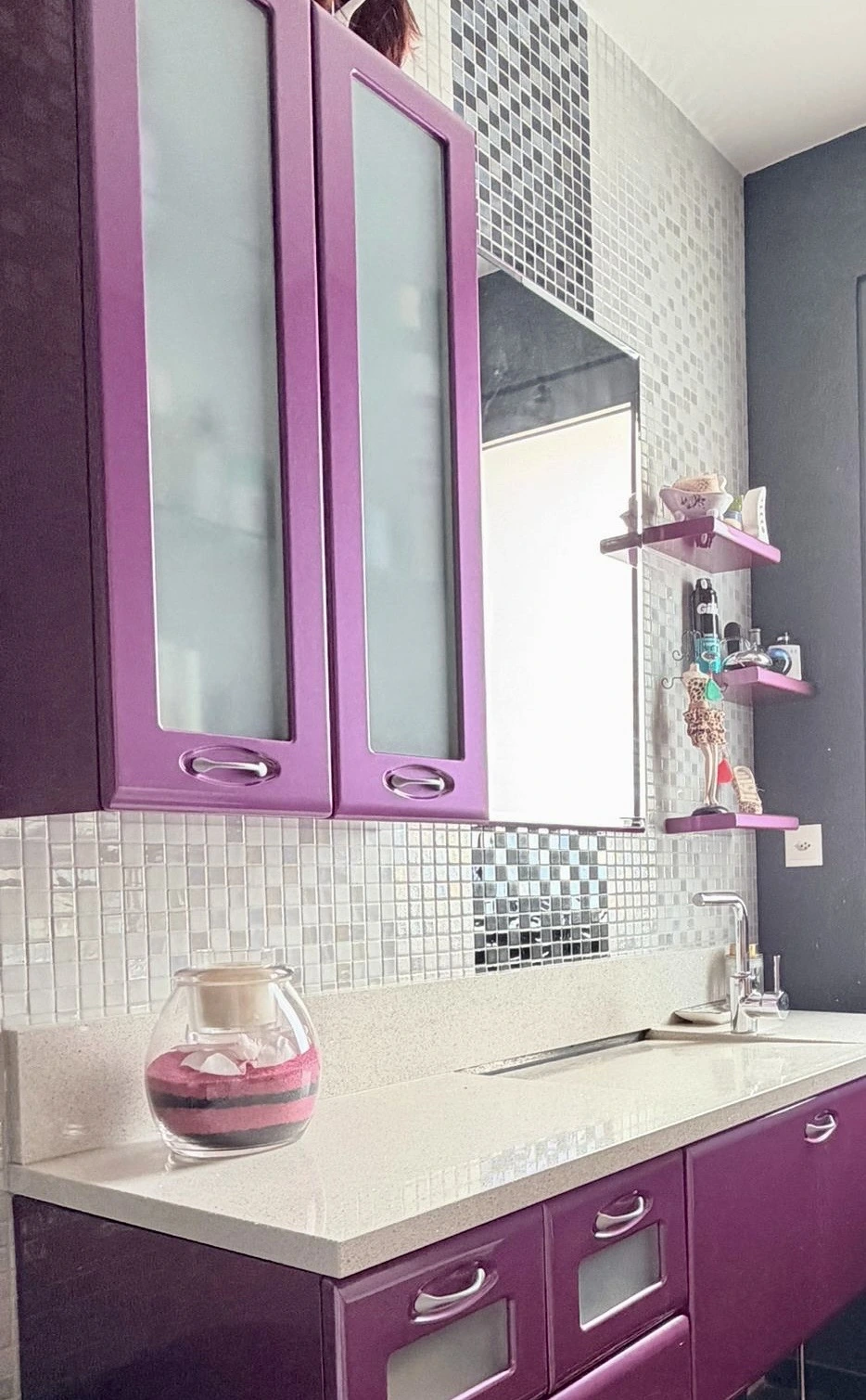 Mosaïque claire et décorative derrière le lavabo et autour du miroir