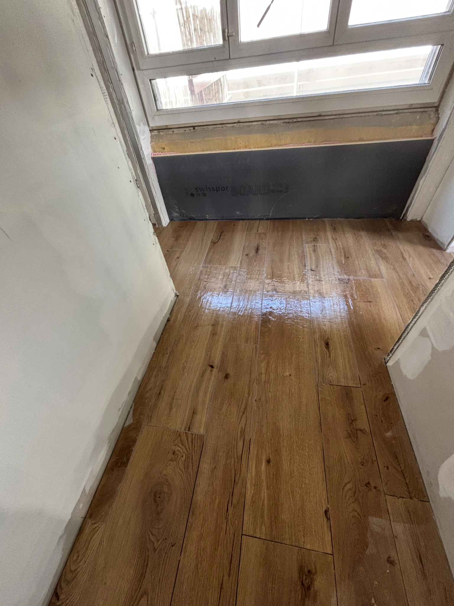 Continuité du carrelage imitation parquet dans le couloir de l’appartement